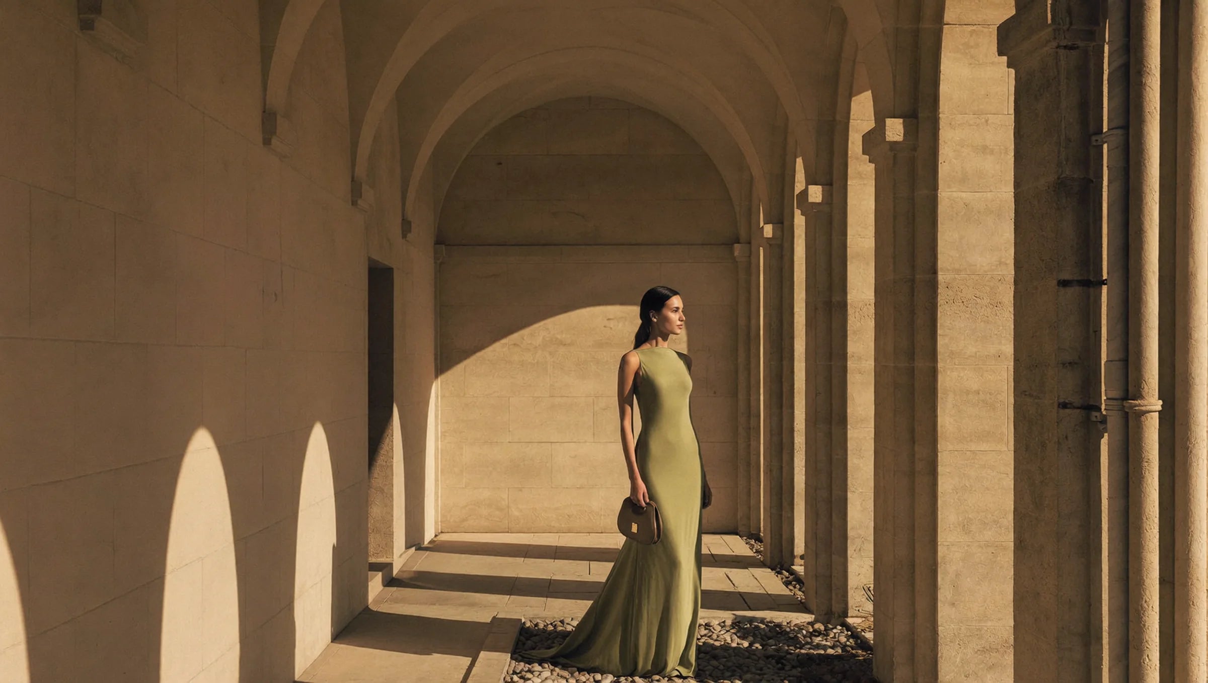 Mujer con vestido largo verde oliva en un claustro